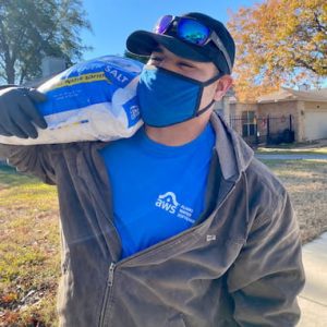Alamo Water Softeners technician carrying a bag of softener salt during delivery